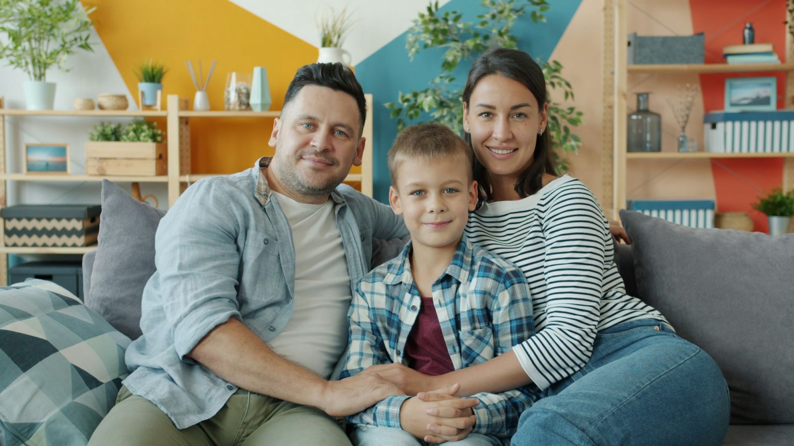 Familie mit Kind auf dem Sofa im neuen Zuhause